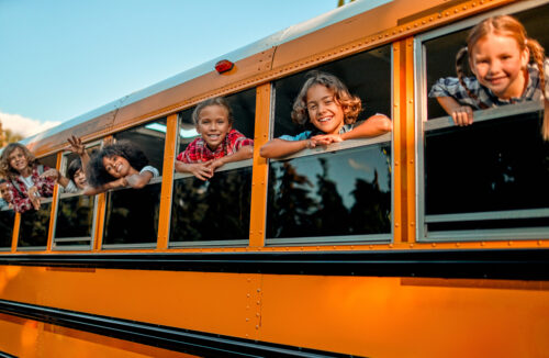 children on a school bus looking out the window